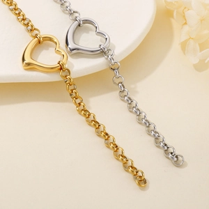 Dettaglio di braccialetti di perle con ciondolo a cuore in oro e argento su un piatto