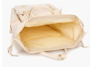 Top view of the interior compartment of a beige mommy diaper bag with organized pockets