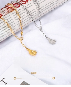 Vue détaillée des colliers pendentifs en forme de cœur et de main en or et argent