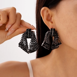 Close-up of elegant black crystal bow tassel drop earrings with luxurious fringe detail