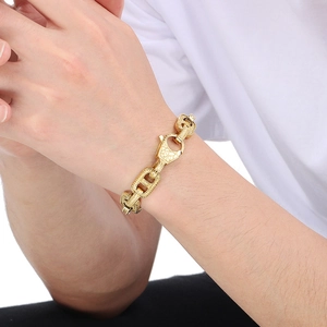 Dettaglio del bracciale da uomo vintage dorato stile punk con motivi floreali a rilievo