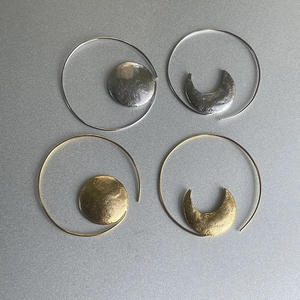 Detailed view of hammered gold and silver sun and moon asymmetric hoop earrings
