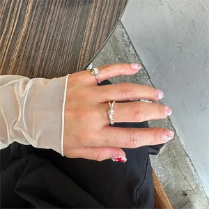 Close-up of minimalist S925 sterling silver beaded and knotted rings on model's fingers