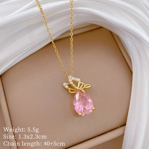 Detailed shot of pink heart pendant with diamond bowknot on a gold-plated chain