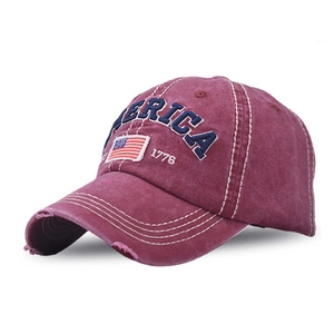 Detail of distressed red cotton baseball cap with America embroidery and USA flag patch