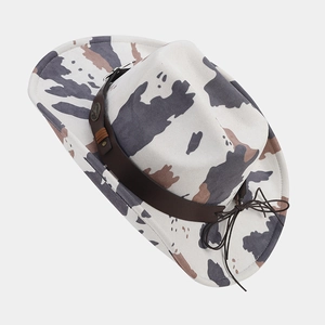 Detail of cow print cowboy hat featuring a leather band and vintage metal studs decoration