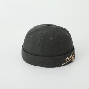 Close-up of black cotton beanie with white embroidered I'm OK text and smiley face detail