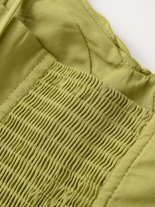 Dettaglio del top verde con smock delicati e trama del tessuto intrecciato
