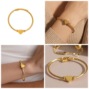 Detail view showing golden heart charm on spiral woven cable bracelet with polished beads