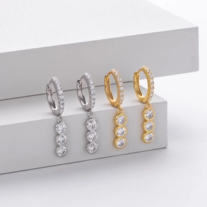 Close-up of S925 sterling silver hoop earrings with cubic zirconia stones on white pedestal