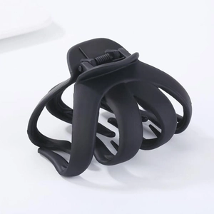 Minimalist matte black octopus hair claw clip with geometric oval design on white background