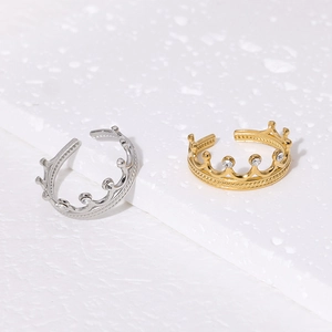 Detailed close-up of 18K gold and silver crown rings with sparkling crystal pavé settings