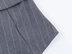 Gros plan sur tissu gris à fines rayures montrant la couture et texture de qualité