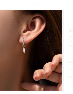 Macro view of water-drop moissanite earrings in silver with pavé diamond detailing
