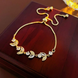 Dettaglio del bracciale a foglia dorata con incastonatura di zirconi e chiusura regolabile