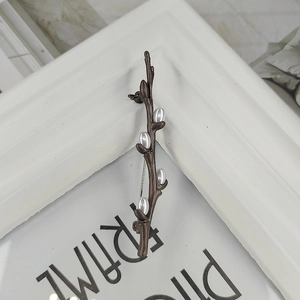 Artistic plum blossom branch brooch with bronze finish and white pearls on white frame