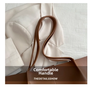 Detail of comfortable brown leather handles on a large vintage-style tote bag