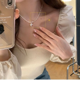 Detail of silver heart pendant necklace on model showcasing a refined珠链 design