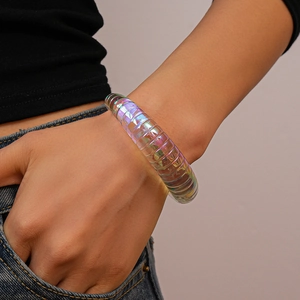 Iridescent acrylic bangle with spiral grooves on model wrist showing colorful reflections