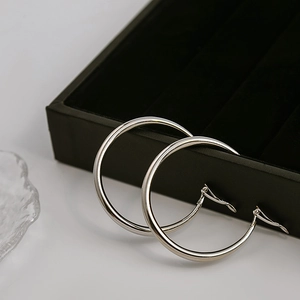 Polished silver large hoop earrings for women in minimalist metal style on display