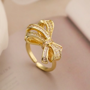 Macro shot of gold bow ring with sparkling zircons and adjustable open band detail