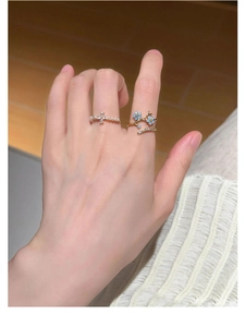 Detailed close-up of s925 silver rings with pearl floral patterns and blue flower accents
