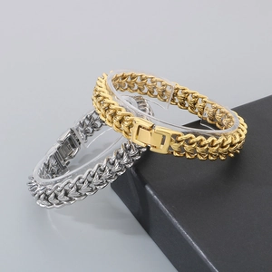 Bracciali a maglia drago in acciaio inossidabile lucido, oro e argento su un supporto