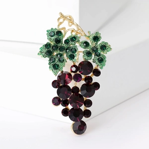 Detail of grape brooch with green crystal leaves and dark purple rhinestones on gold base