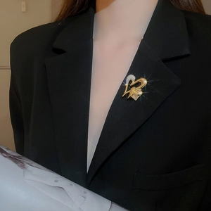 Detailed view of sparkling heart brooch with crystals on a black suit lapel