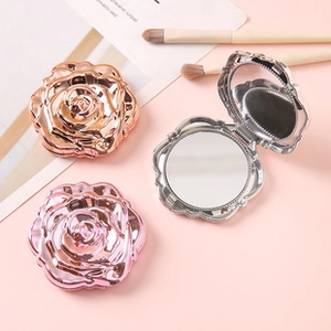 Detailed view of rose-shaped compact mirrors in rose gold, pink and silver finishes
