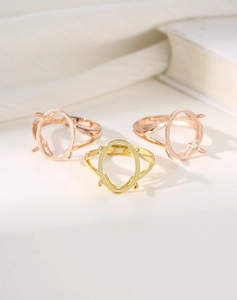 Detailed view of oval four-prong ring settings in gold and rose gold finishes