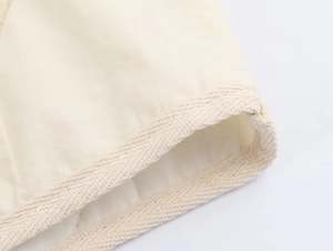 Detailed macro view of beige cotton blend jacket fabric with reinforced woven ribbon texture