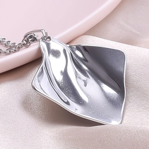 Macro view of silver wavy crinkle pendant necklace with high-polish metallic texture