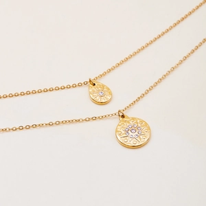 Close-up of 18K gold stainless steel necklace with teardrop and starburst pendants