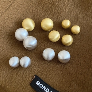 Detail of matte gold and silver brushed round beads in assorted sizes for jewelry making