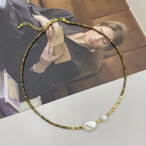 Detail of baroque pearl and tourmaline beaded necklace on a vintage poster background