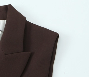 Detailed macro view of dark brown suit vest fabric showing stitching and lapel texture