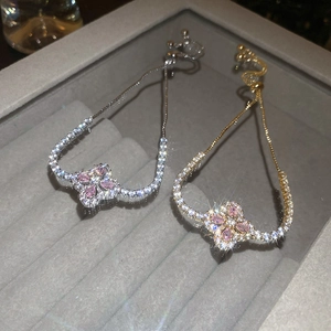 Détails de bracelets en or et argent avec trèfles sertis de pierres marquises roses