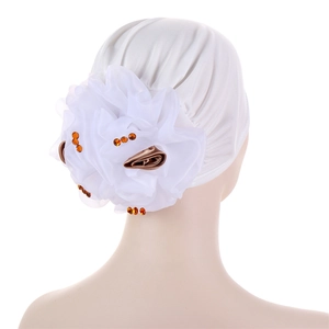 Detail view of large white floral applique with amber rhinestones on a turban headwrap