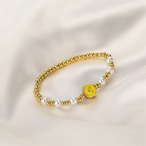 Détail du bracelet avec perles dorées, perles et pendentif lettre C en émail jaune