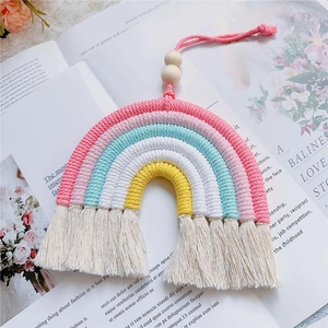 Close-up of handmade rainbow wall hanging with colorful cotton ropes and wood beads
