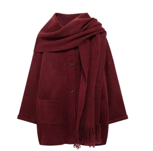 Dettaglio del cardigan in maglia bordeaux con trama spessa e sciarpa con frange