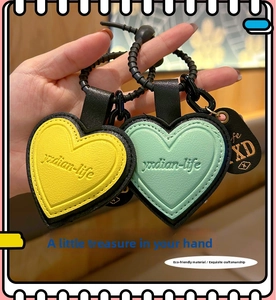 Detail view of heart-shaped faux leather keychains in yellow and mint green colors