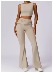 Detail of high-waist flared yoga leggings with pleated waistband in beige finish