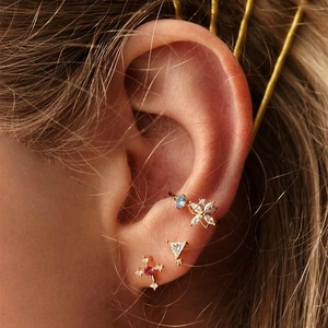 Macro detail of S925 silver gold-plated ear cuff and stud set with colorful crystals
