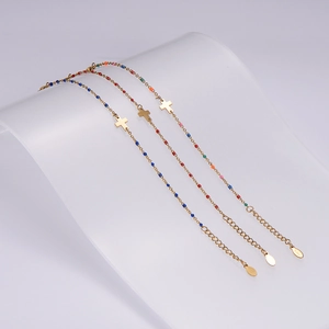 Dettagli di bracciali in acciaio inossidabile con perline colorate e ciondoli a croce