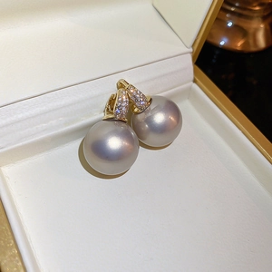 Macro detail of elegant grey pearl earrings with sparkling zircon butterfly accents
