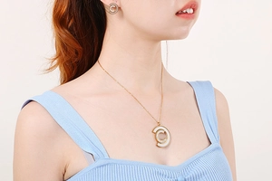Detail shot of the stainless steel gold chain necklace and matching C-shape shell earrings