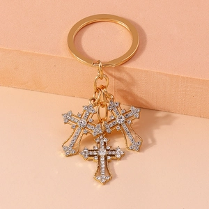 Detailed shot of golden cross keychains with rhinestones on a warm display stand
