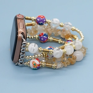 Detail of bohemian beaded watch strap for Apple Watch featuring floral ceramic and gold accents
